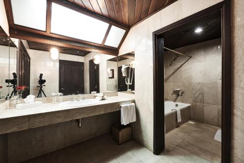 a bathroom with two sinks and a tub and a window at Safari Park Hotel in Nairobi