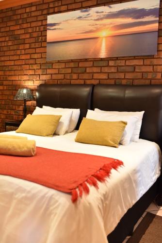 a bedroom with two beds with a leather headboard at The Cedars Bed and Breakfast in Centurion