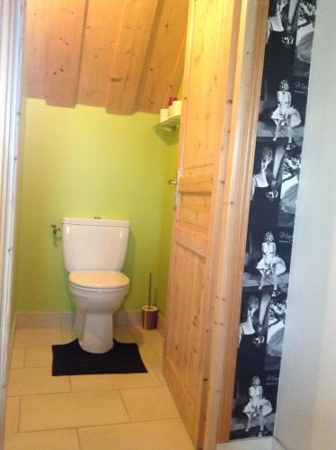 a bathroom with a white toilet in a room at Chez MARLENE in Quettehou