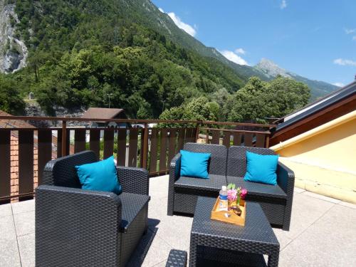 a balcony with two chairs and a table with blue pillows at Hôtel Du Midi in Thônes
