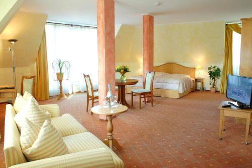 ein Hotelzimmer mit einem Bett und einem Sofa in der Unterkunft Hotel Leipzig City Nord by Campanile in Leipzig