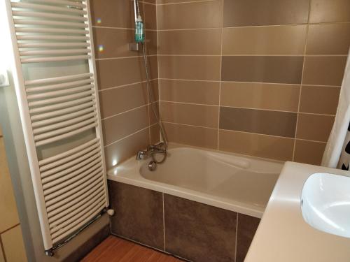 a bathroom with a bath tub and a sink at Chambre Chaleureuse chez l'habitant in Bourg-en-Bresse