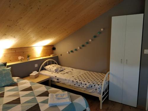 um pequeno quarto com uma cama e um tecto em madeira em Chambre Chaleureuse chez l'habitant em Bourg-en-Bresse