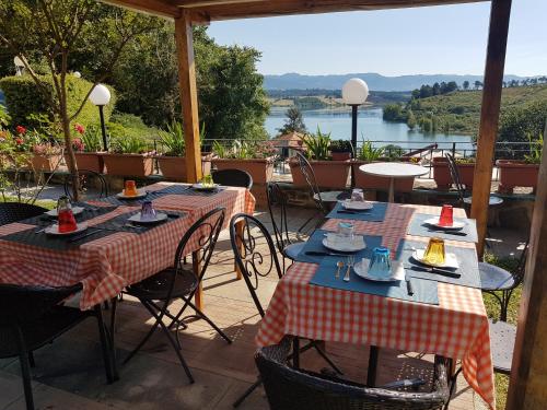 eine Terrasse mit Tischen und Stühlen und Seeblick in der Unterkunft Casa Vacanze Borgo la Fratta in Barberino di Mugello