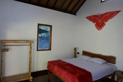 a bedroom with a bed with a butterfly sign on the wall at Sunset Springs Beach Retreat in Papak