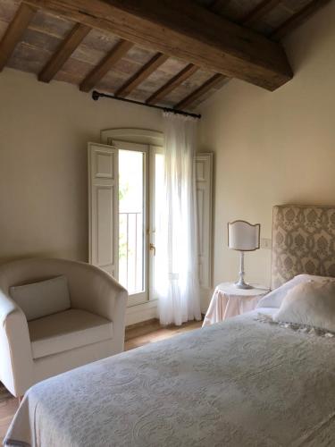 una camera con un letto e una sedia e una finestra di Le Case Di San Vitale Easy a Ravenna