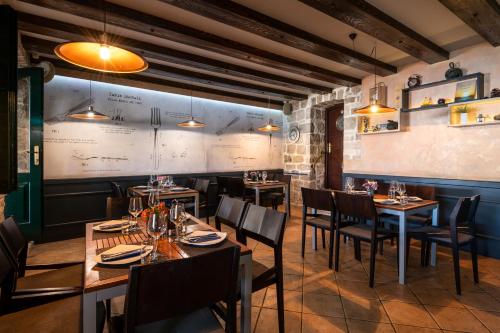 a restaurant with wooden tables and chairs and a chalkboard at Boutique B&B Villa Faggioni in Cavtat