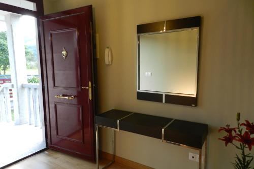 a bathroom with a mirror next to a door at Chalet Adosado Allariz in Allariz