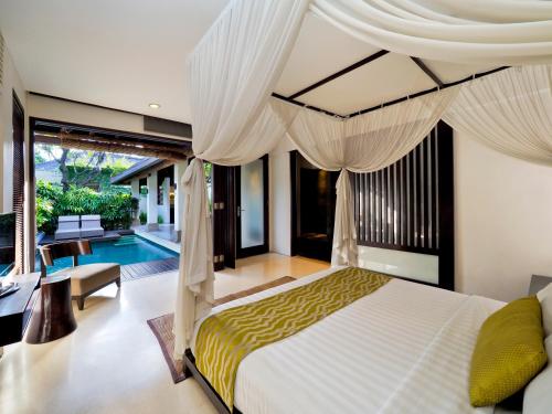 a bedroom with a bed and a swimming pool at The Amala Boutique Retreat in Seminyak