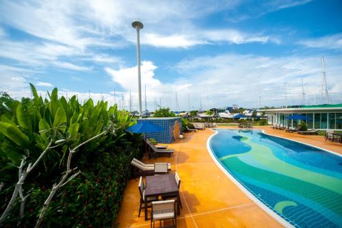 una piscina en la azotea de un hotel con mesas y sillas en Krabi Boat Lagoon Resort en Krabi