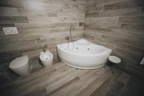 a bathroom with a white bath tub and a toilet at Cascina Speranza Hotel in Riva presso Chieri