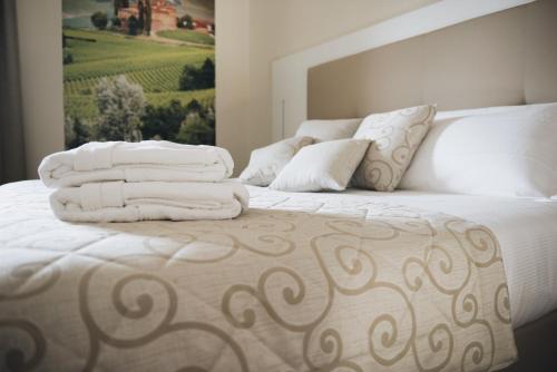 a bedroom with a bed with white sheets and pillows at Cascina Speranza Hotel in Riva presso Chieri