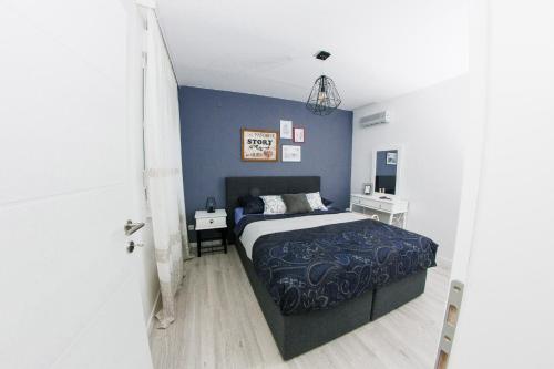 - une chambre avec un lit et un mur bleu dans l'établissement Apartment Ella, à Čapljina