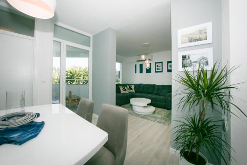 une salle à manger avec une table blanche et des plantes dans l'établissement Apartment Ella, à Čapljina