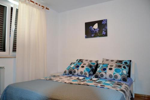 a bedroom with a bed with blue and white pillows at Apartment Istrian view in Šmarje