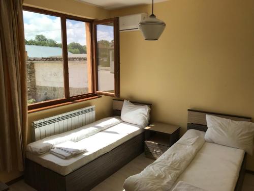 a room with two beds in front of a window at Complex Trakite in Elkhovo