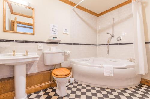 a bathroom with a tub and a toilet and a sink at The Vestry in Chichester