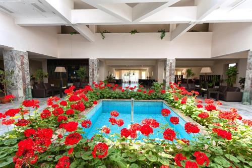 エレバンにあるRegineh Hotelの赤い花とプールで満たされた部屋