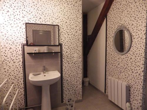 ein Bad mit einem Waschbecken und einem Spiegel in der Unterkunft Gite 32 rue du huit mai in Freneuse