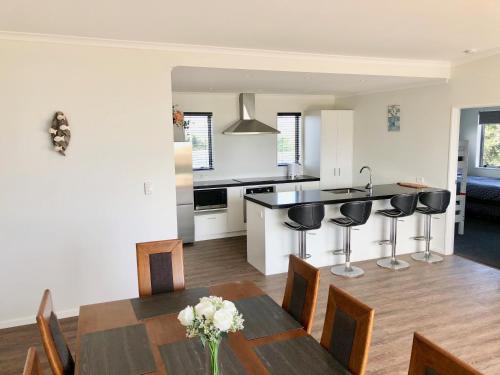 a kitchen and dining room with a table and chairs at Otaki Beachfront Getaway in Otaki Beach