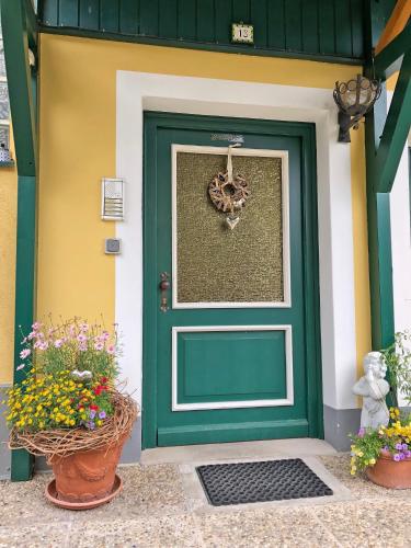 a green door with flowers in front of a building at Appartements am Kurpark in Bad Mitterndorf
