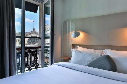 1 dormitorio con cama y ventana grande en Hôtel Le Marcel Paris Gare de l'Est, en París