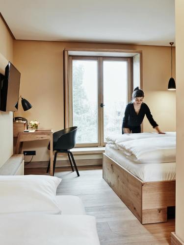 a woman making a bed in a hotel room at Hotel Wedina an der Alster in Hamburg