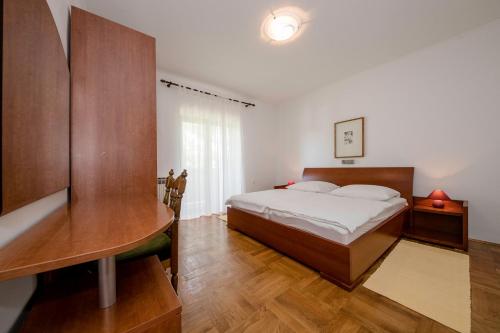 a bedroom with a bed and a desk and a table at Apartments Dedić in Supetarska Draga