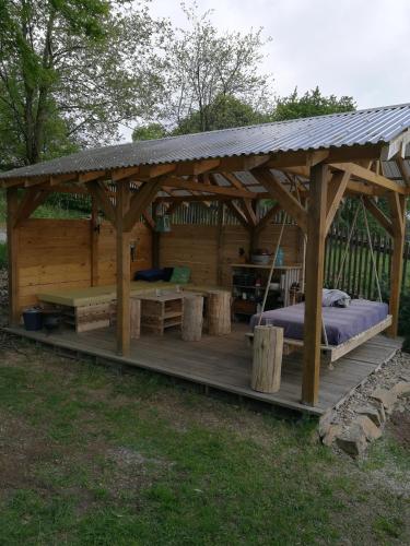 a wooden gazebo with a bed and benches at Apartmany Bublava 817 in Bublava