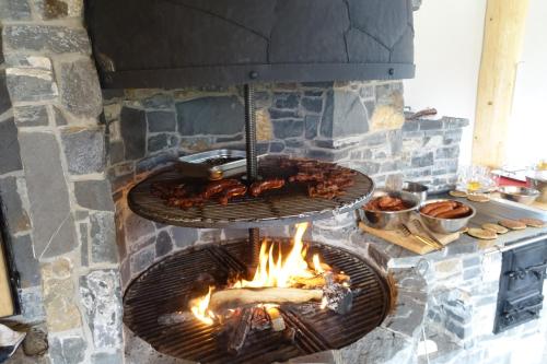 a stone oven with chickens cooking over a fire at Willa Zaolzie in Istebna