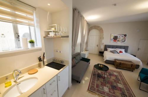 a bathroom with a sink and a room with a bed at Mamilla Design Apartments in Jerusalem