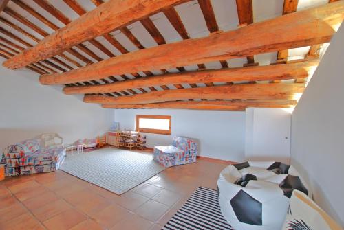 an attic room with a wooden ceiling and chairs at The Painter's Home in Vilassar de Mar