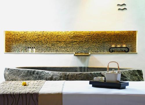 a bathroom with a sink and a bed with a tub at The Amala Boutique Retreat in Seminyak