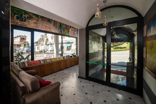 a living room with a couch and a glass door at Hotel Italia & Lombardi in Montefiascone