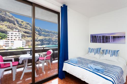 a bedroom with a bed and a table and chairs at Studio Atlantic View in Icod de los Vinos