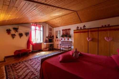 - une chambre avec un lit et une couverture rouge dans l'établissement Ai Due Pini B&B, à Pescantina