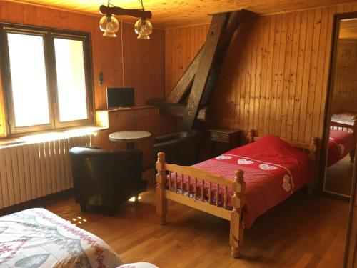 a bedroom with a bed and a chair in a room at La Chicholiere in Gresse-en-Vercors