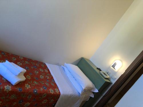 a hotel room with a bed with blue pillows at Hotel Lukas Vegetarian & Vegan in Viareggio