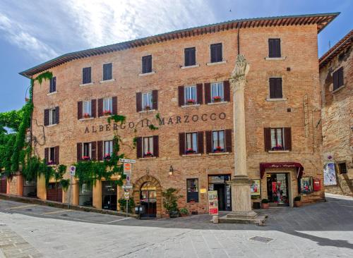 a large brick building with the words alberoit marococo at Albergo Il Marzocco dal 1860 in Montepulciano