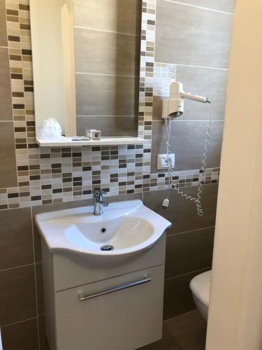 a bathroom with a sink and a mirror and a toilet at Hotel Lukas Vegetarian & Vegan in Viareggio