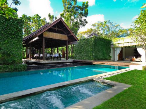 a swimming pool with a gazebo in a yard at The Amala Boutique Retreat in Seminyak