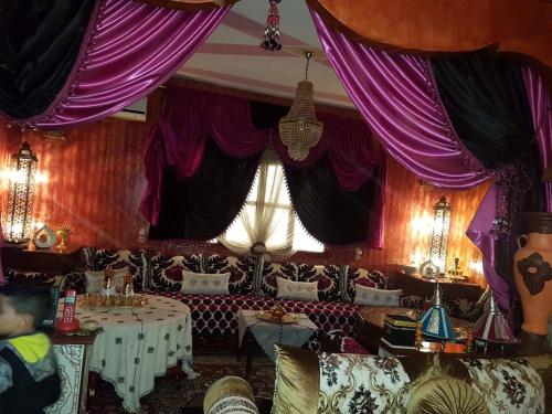 a dining room with tables and purple drapes at Kasabah Senhaji in Moulay Idriss Zerhoun