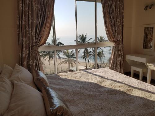 a bedroom with a large window with a view of the beach at Seabrook 403 Margate RSA in Margate