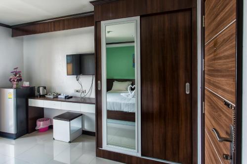 a room with a bed and a desk with a mirror at Kulasub Hotel in Hat Yai