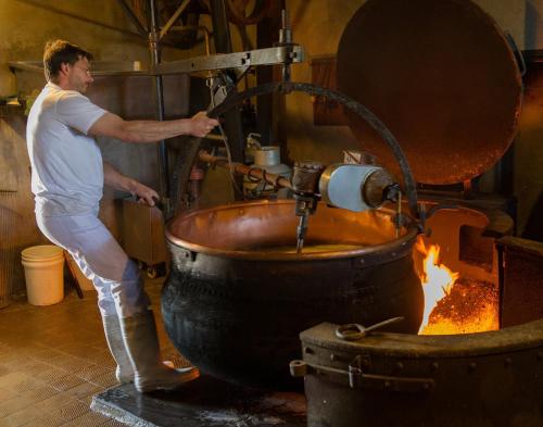 a man standing in front of a pot on fire at 8 Chalets - Les Lodges du Hérisson - à 1500m des cascades in Bonlieu
