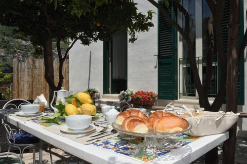 a table with a plate of bread and fruit on it at Nicola e Magda in Ravello