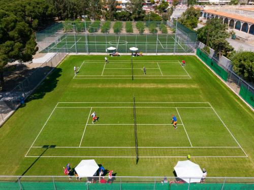 a group of people playing tennis on a tennis court at Apollo Beach in Faliraki