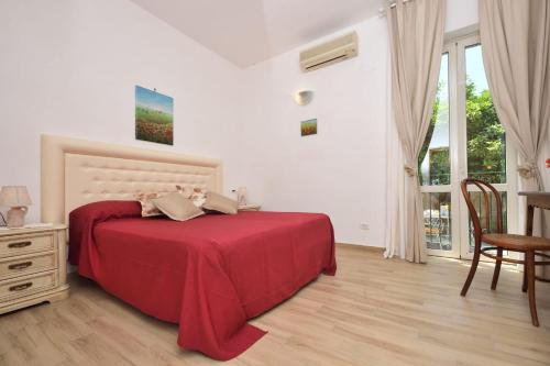 a bedroom with a red bed and a table and chairs at Nicola e Magda in Ravello