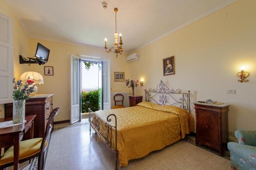 a bedroom with a bed and a table and a desk at Albergo Il Marzocco dal 1860 in Montepulciano