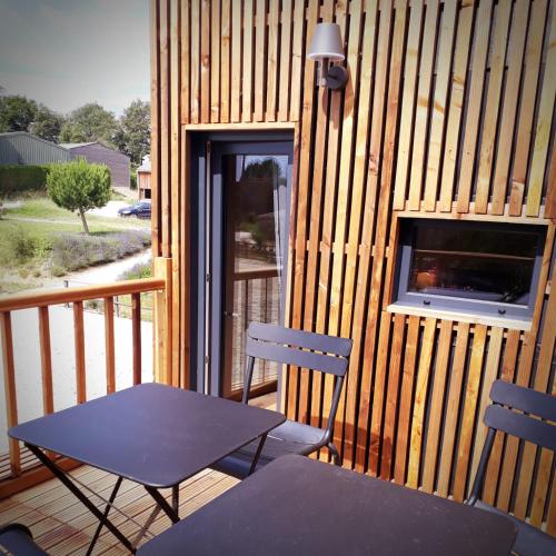 a table and two chairs on a wooden deck at Manège de la Chapinière - DadaLoge tiny-house in Châteauvieux